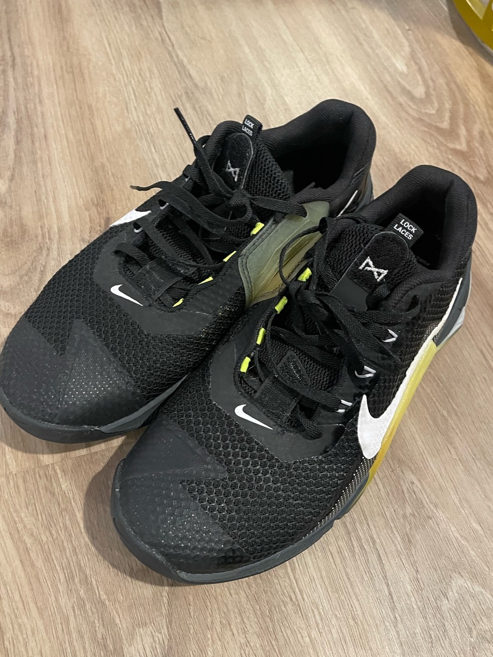Nike Metcon 7 black sneakers with white Nike swoosh and yellow accents